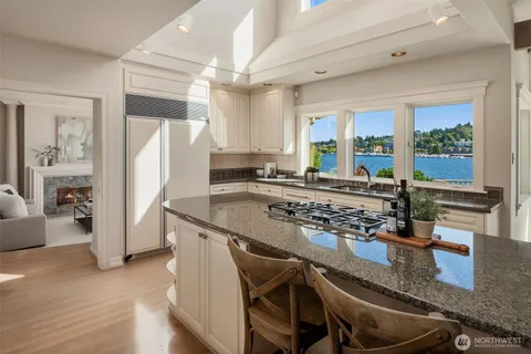 a kitchen with granite countertop a stove a refrigerator and a counter space
