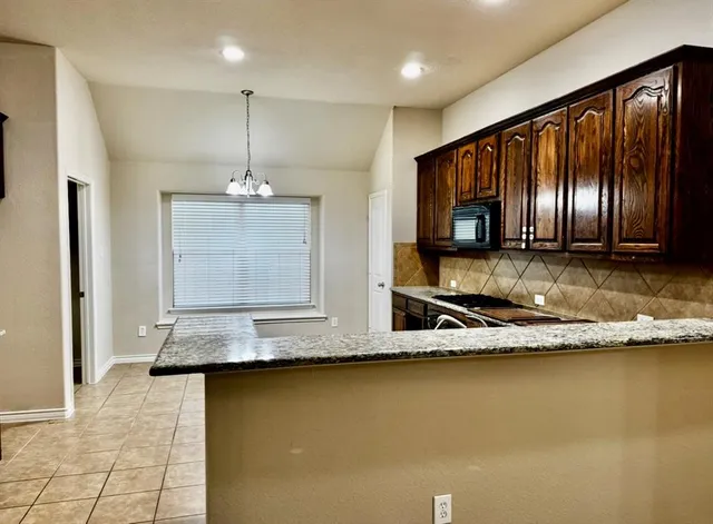 a kitchen with kitchen island granite countertop cabinets and stainless steel appliances