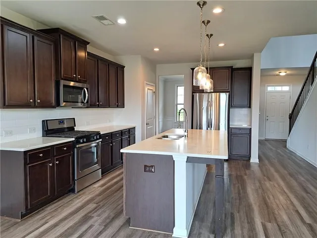 a view of a big room with wooden floor and windows