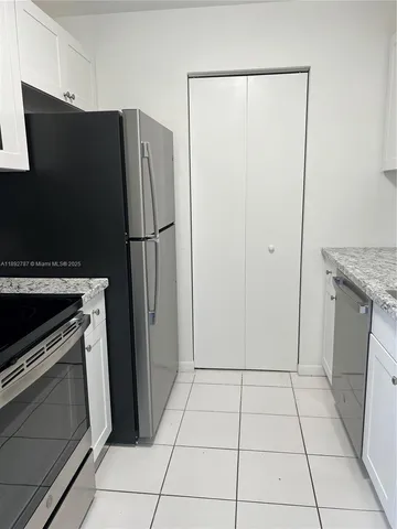 a kitchen with a refrigerator and a stove top oven