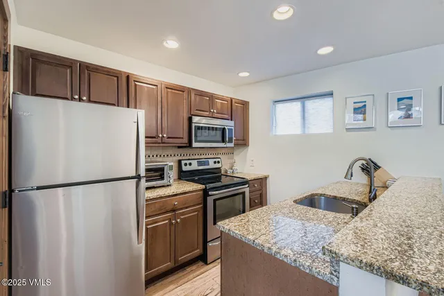 a kitchen with a table chairs refrigerator and microwave