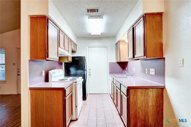 a kitchen with stainless steel appliances granite countertop a stove and a refrigerator