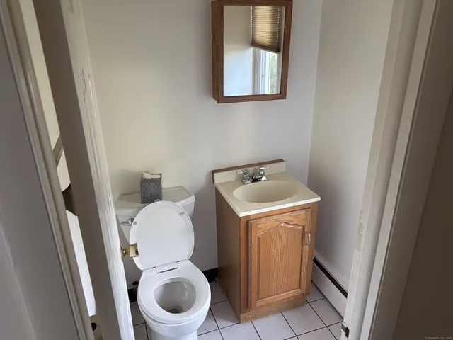a white toilet sitting in a bathroom next to a sink