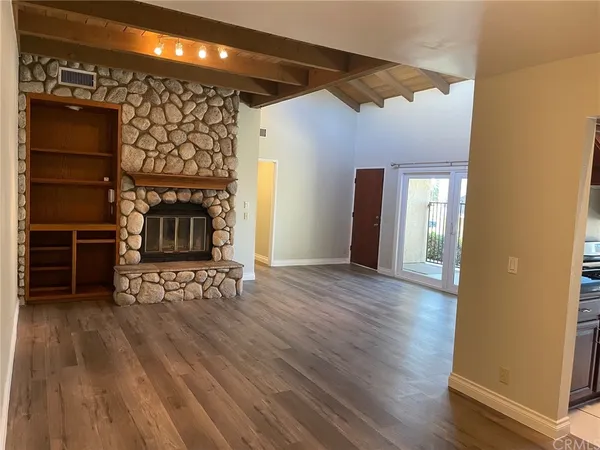 a view of a livingroom with wooden floor and a fireplace