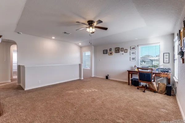 a view of a livingroom with furniture and a ceiling fan