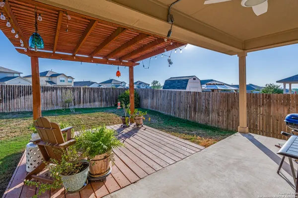 a view of a backyard with couches plants and wooden fence