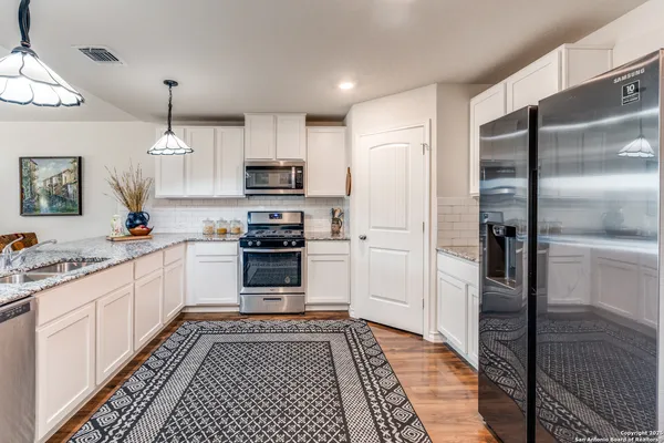 a kitchen with stainless steel appliances a refrigerator sink and cabinets
