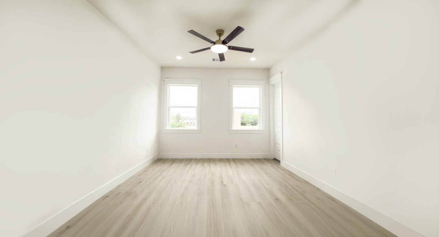823 North Loop Houston, TX 77022 - Photo 10 of 23 an empty room with wooden floor chandelier fan and windows