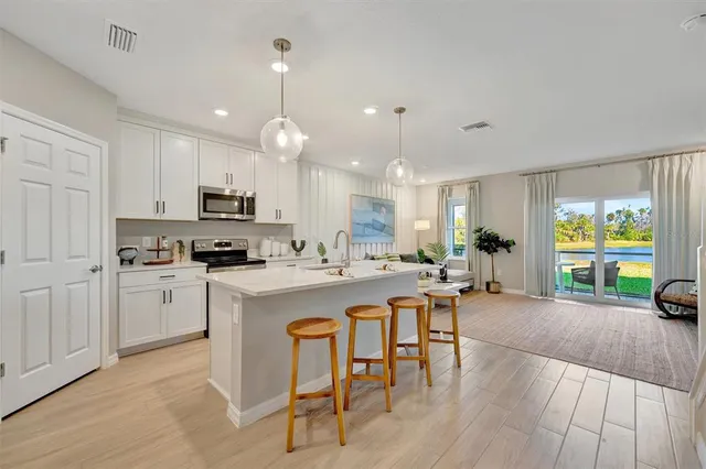 a kitchen with kitchen island granite countertop a refrigerator oven a sink and a stove