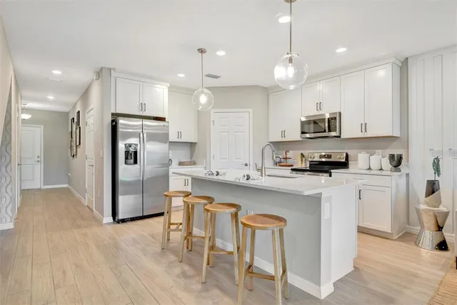a large white kitchen with a table and chairs