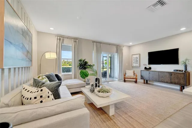 a living room with furniture and a dining table with kitchen view