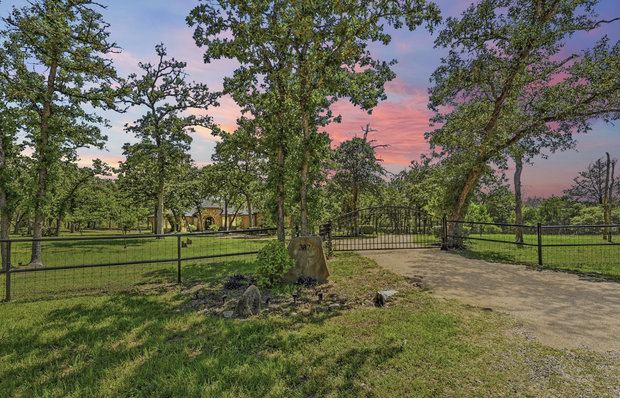 387 Corral Road Smithville, TX 78957 - Photo 8 of 40 Gated entry with stone columns and wrought iron fencing
