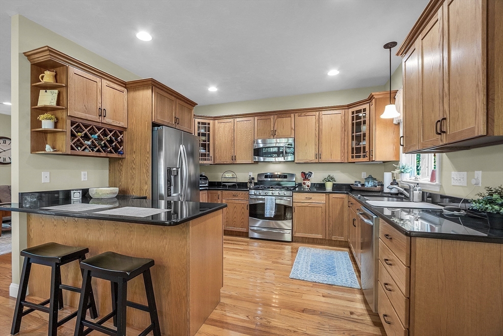 124 Nicholas Drive Lancaster, MA 01523 - Photo 14 of 42 a kitchen with kitchen island granite countertop wooden cabinets and refrigerator