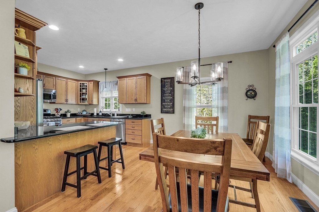 124 Nicholas Drive Lancaster, MA 01523 - Photo 18 of 42 a kitchen with kitchen island granite countertop a dining table chairs and granite counter tops
