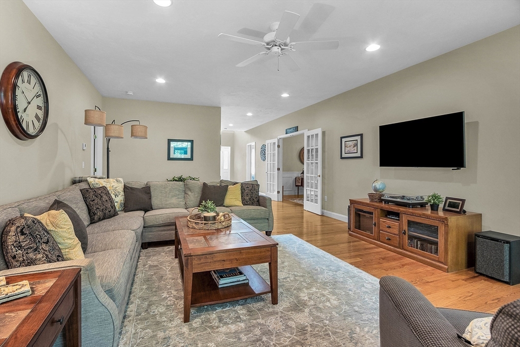 124 Nicholas Drive Lancaster, MA 01523 - Photo 20 of 42 a living room with furniture a flat screen tv and a clock