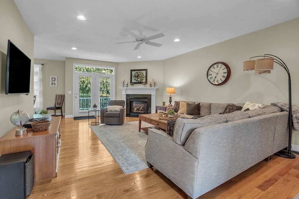 124 Nicholas Drive Lancaster, MA 01523 - Photo 22 of 42 a living room with furniture a fireplace and a flat screen tv