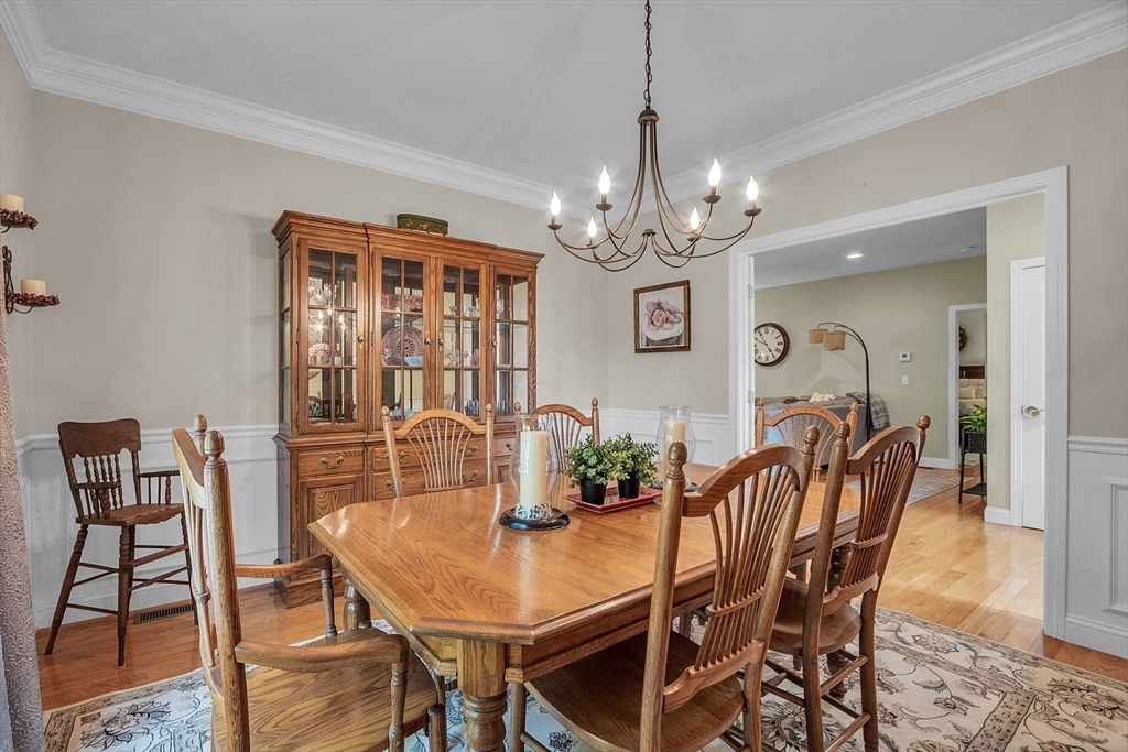 124 Nicholas Drive Lancaster, MA 01523 - Photo 26 of 42 a view of a dining room with furniture a chandelier and wooden floor