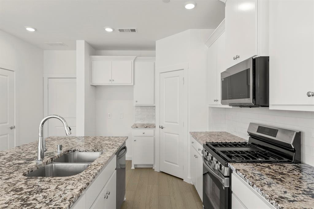 1827 Azalea Drive Melissa, TX 75454 - Photo 11 of 38 a kitchen with sink a stove and a microwave