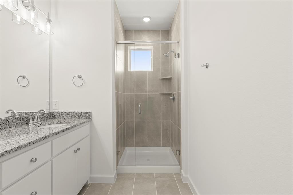 1827 Azalea Drive Melissa, TX 75454 - Photo 21 of 38 a bathroom with a granite countertop sink a mirror and shower