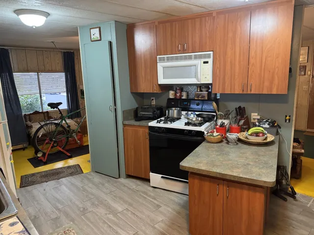 a view of a kitchen with fridge and workspace