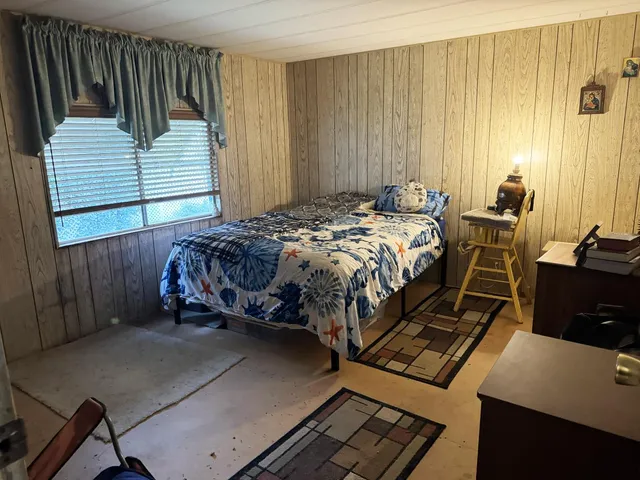 a bed sitting in a bedroom next to a window