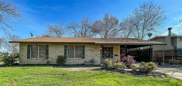 a view of a house with a yard chairs and table in a patio