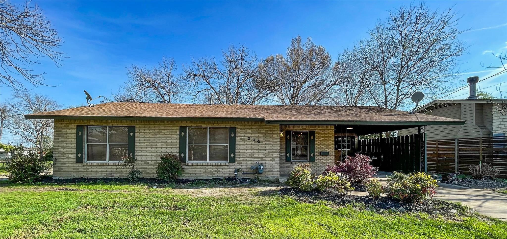 a view of a house with a yard chairs and table in a patio