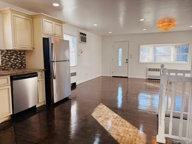a view of a kitchen with wooden floor and a refrigerator