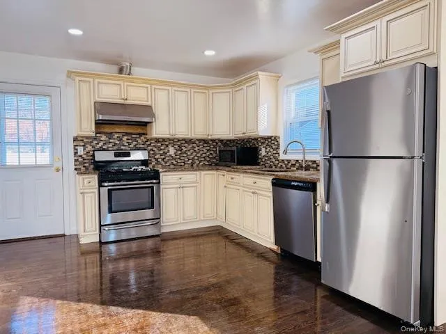 a kitchen with stainless steel appliances a refrigerator sink and microwave
