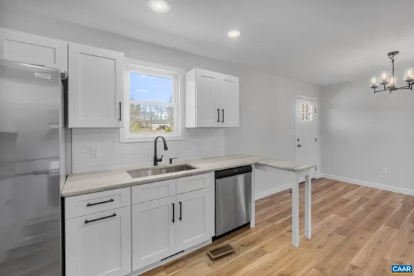 a kitchen with a sink cabinets and wooden floor
