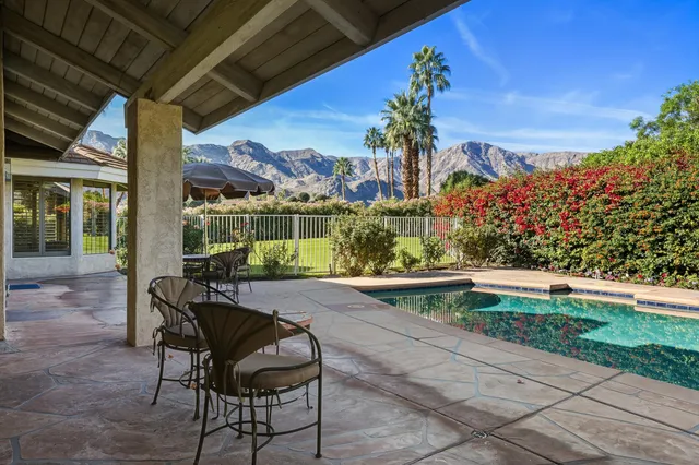 a view of a patio with a table chairs and a garden