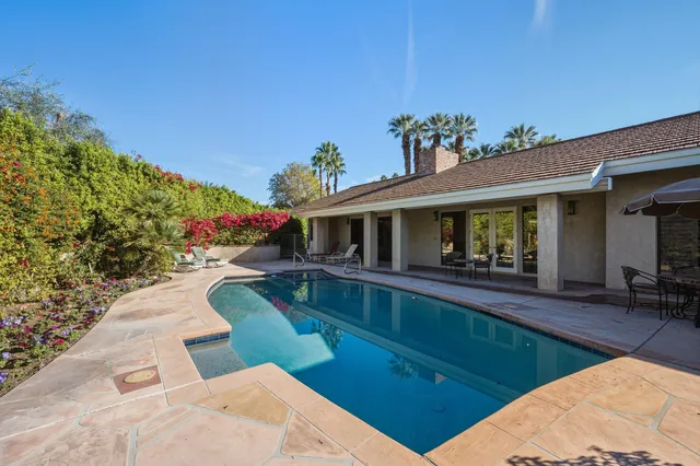 a view of house with swimming pool outdoor seating