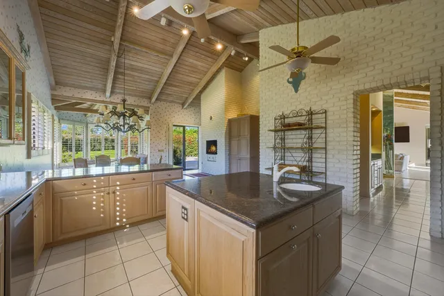 a kitchen with granite countertop a sink a counter top space and stainless steel appliances