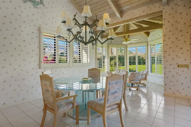 a dining room with furniture and large windows
