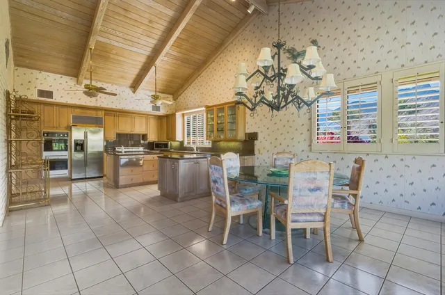 a dining room with stainless steel appliances kitchen island granite countertop a table and chairs