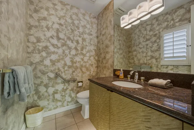 a bathroom with a granite countertop sink a toilet and a mirror