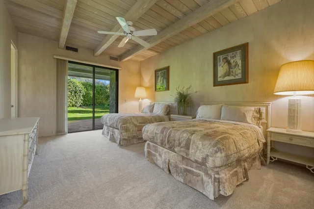a spacious bedroom with two beds and a chandelier
