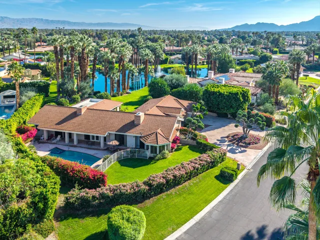 an aerial view of a house with a garden and lake view