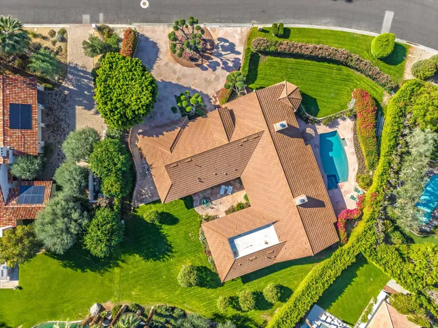 an aerial view of a house with a garden and swimming pool