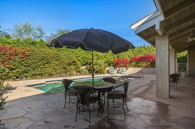 a view of patio with a table and chairs under an umbrella