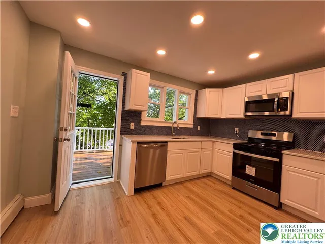 a kitchen with stainless steel appliances granite countertop a stove a sink and a microwave
