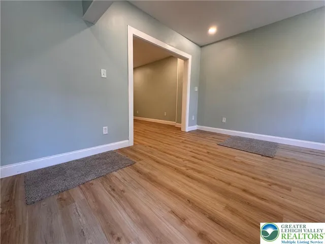 a view of an empty room with wooden floor