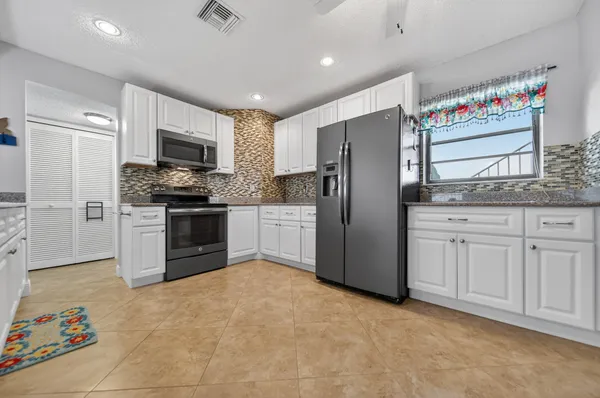 a kitchen with stainless steel appliances granite countertop a stove a sink and a microwave