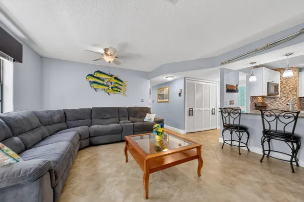 a living room with furniture a ceiling fan and a window