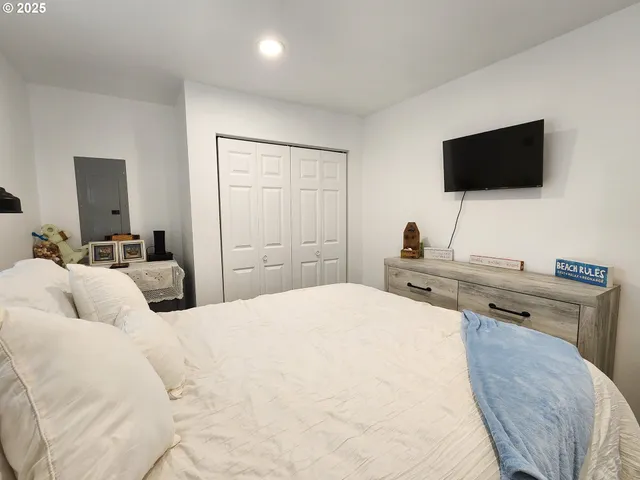 a bedroom with a bed and a flat screen tv