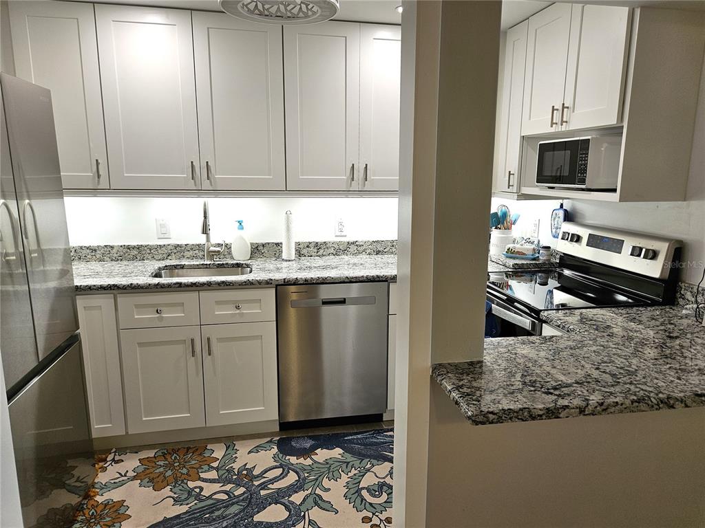 519 Albee Farm Road, Unit 114 Venice, FL 34285 - Photo 11 of 21 a kitchen with stainless steel appliances granite countertop a sink stove and cabinets