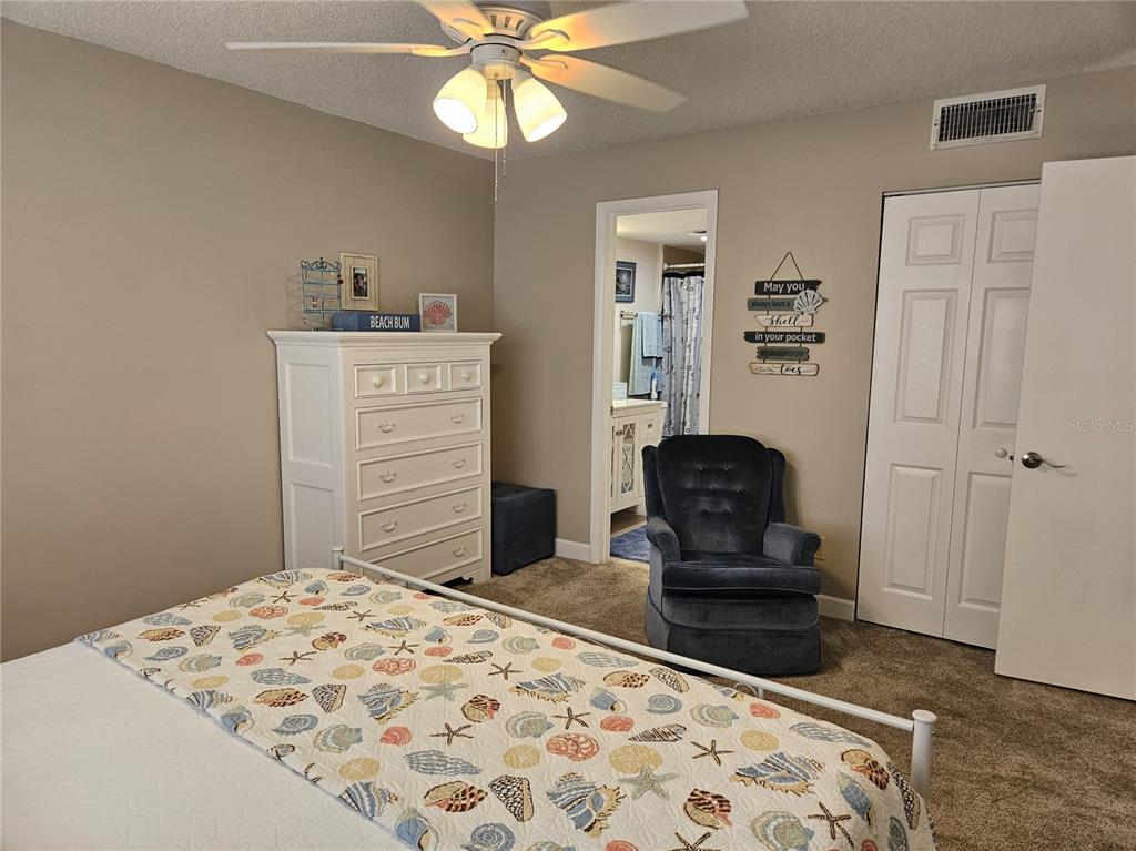 519 Albee Farm Road, Unit 114 Venice, FL 34285 - Photo 14 of 21 a bedroom with a bed and a chair