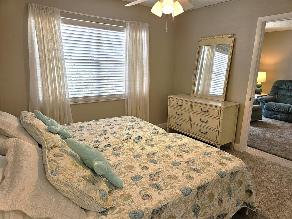 519 Albee Farm Road, Unit 114 Venice, FL 34285 - Photo 17 of 21 a bedroom with a bed and a chandelier