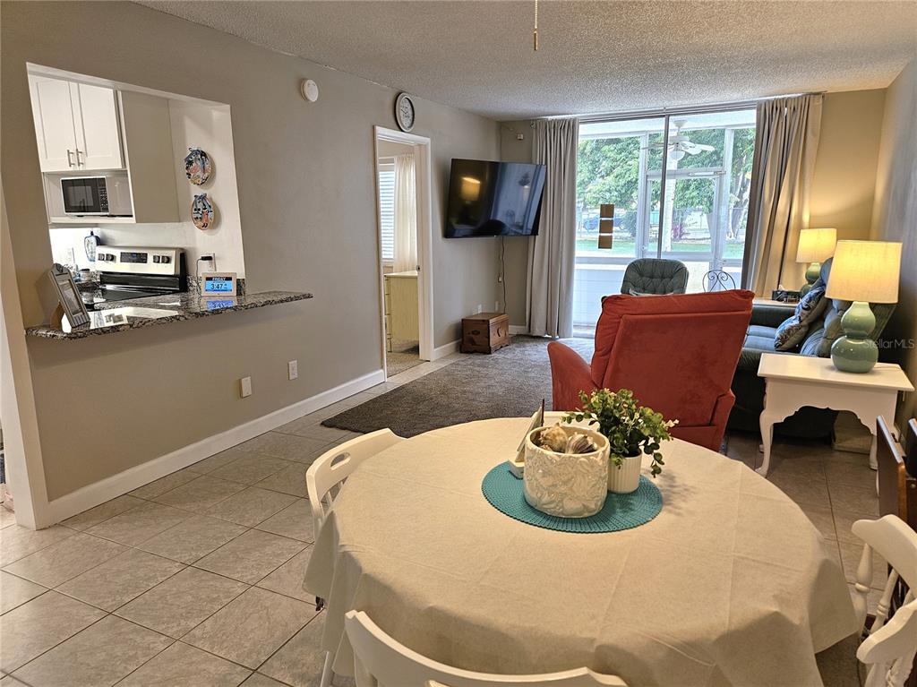 519 Albee Farm Road, Unit 114 Venice, FL 34285 - Photo 4 of 21 a living room with furniture and a flat screen tv