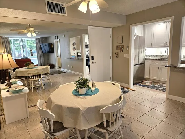 a dining room with furniture a chandelier and wooden floor